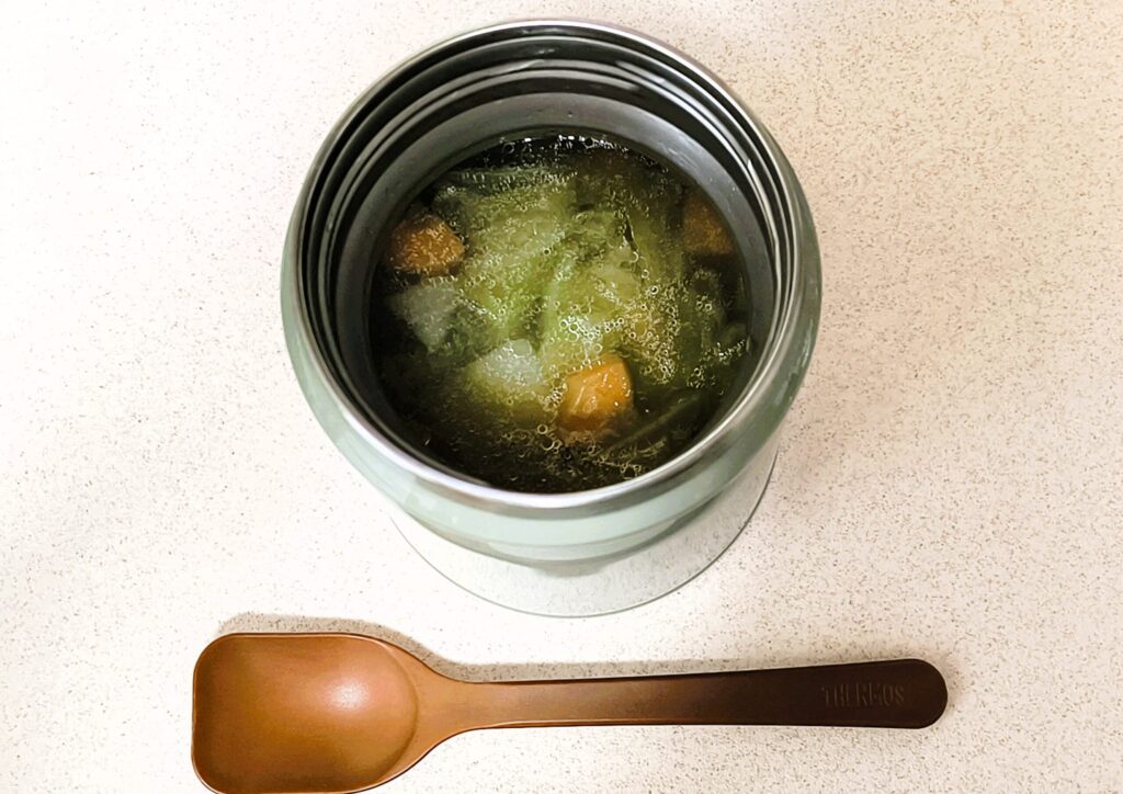 スープジャーに入れてスプーンを添えたスープ