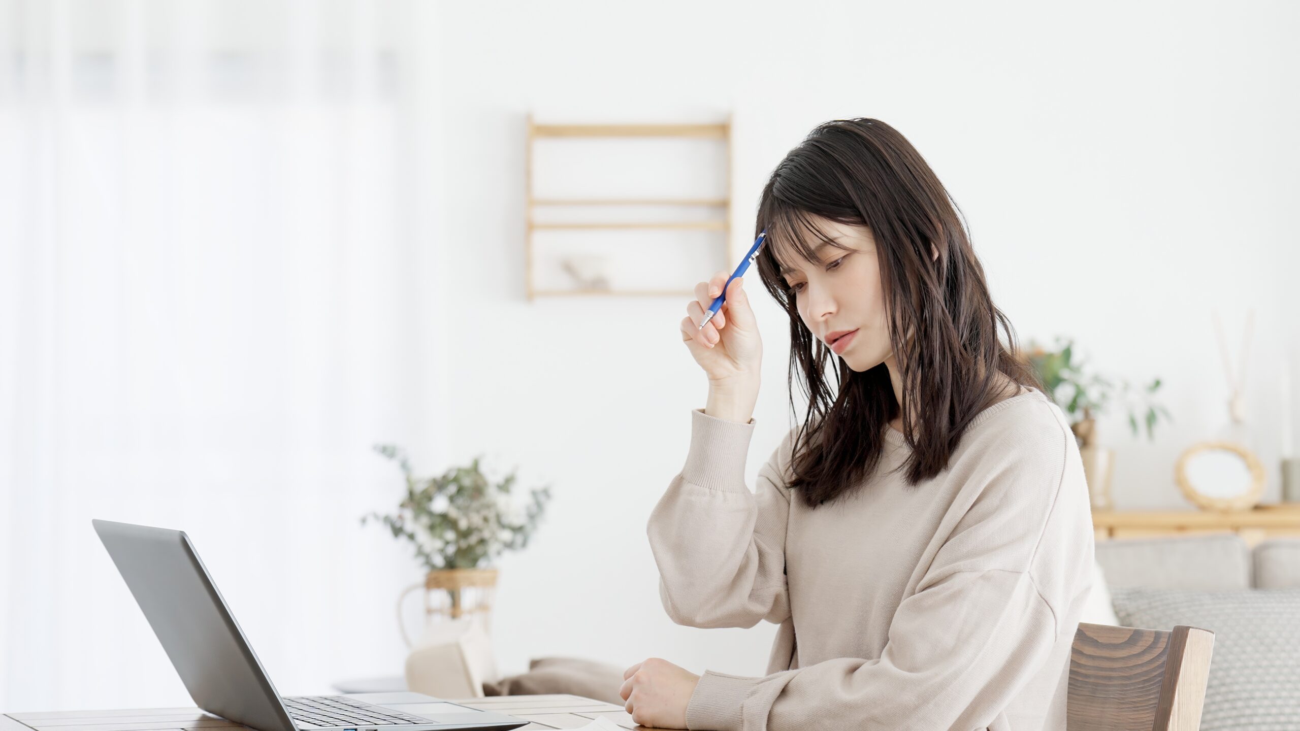 リビングで悩んでいる母親の様子