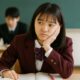 中学校の教室で授業を聞いているけれど上の空になっている女子の様子